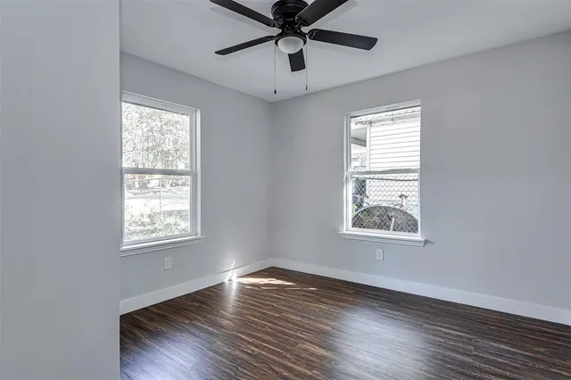 a view of empty room with wooden floor