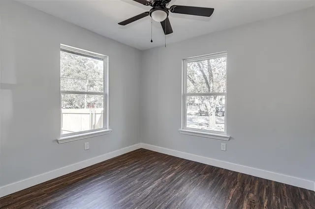 a view of empty room with wooden floor