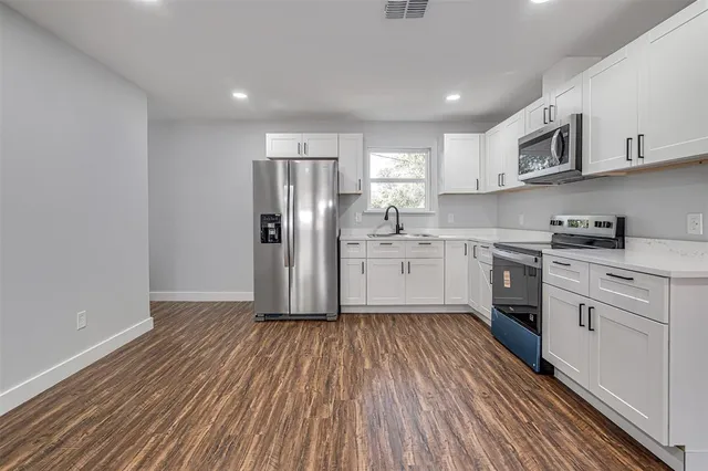 a view of a kitchen with a sink and a refrigerator