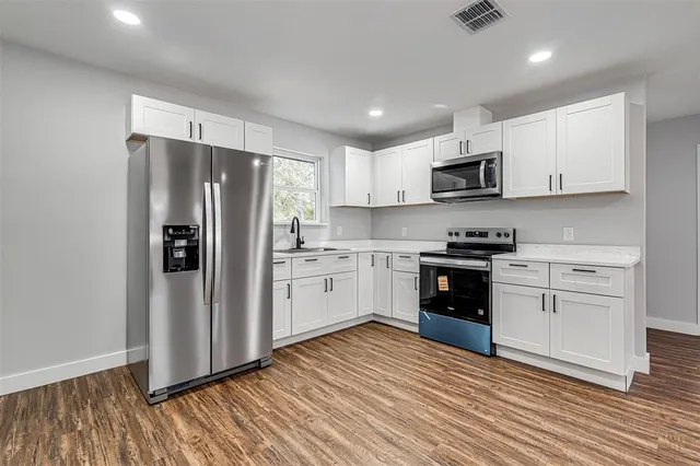 a kitchen with stainless steel appliances a white cabinets and sink