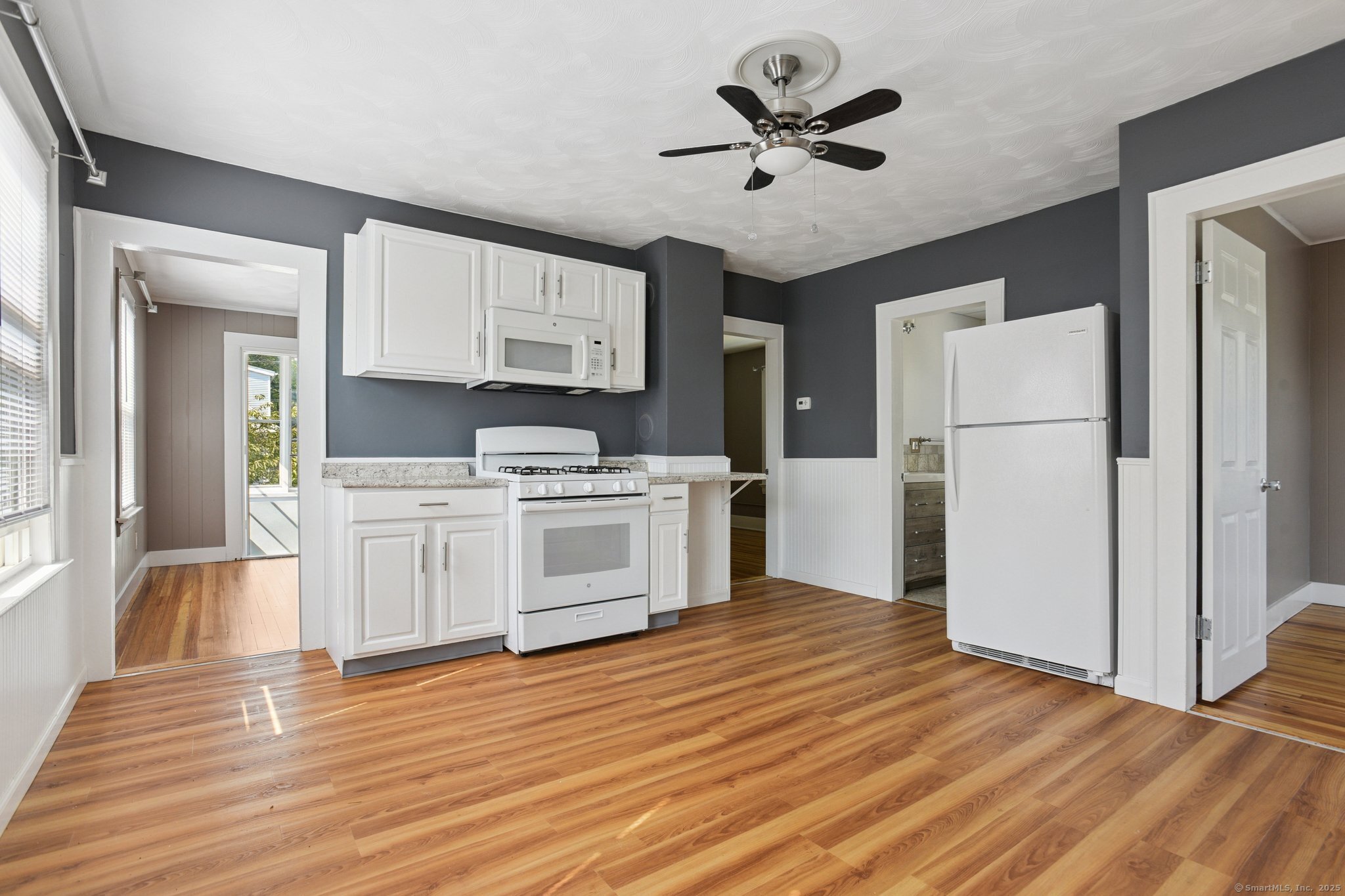 14 East Street, Unit 2 Wallingford, CT 06492 - Photo 2 of 6 a kitchen with stainless steel appliances a white refrigerator a sink a stove and white cabinets with wooden floor