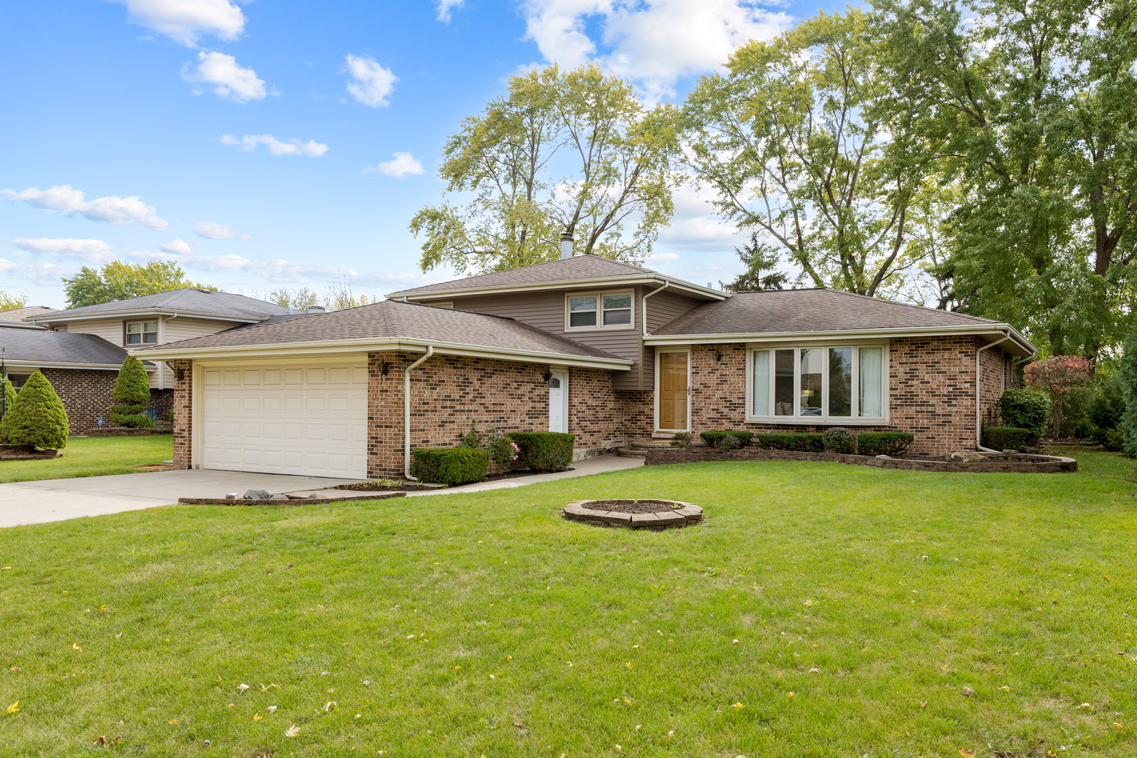 a front view of a house with yard and trees