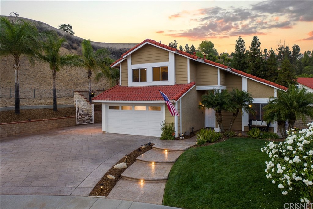 a front view of a house with a yard and potted plants