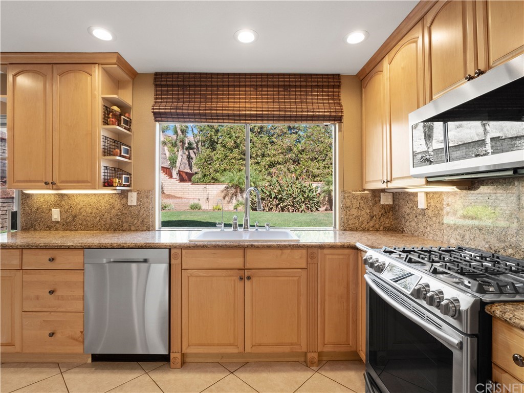 28043 Nantucket Street Castaic, CA 91384 - Photo 11 of 61 a kitchen with stainless steel appliances granite countertop a stove and a sink