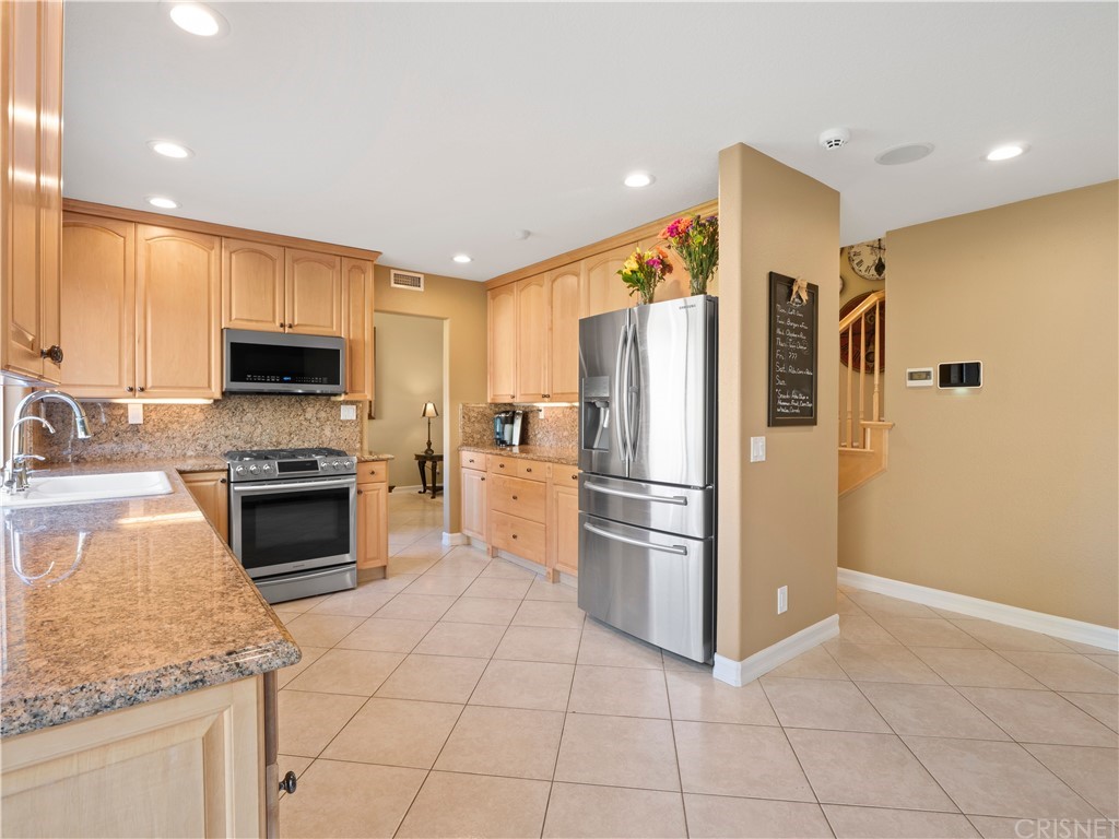28043 Nantucket Street Castaic, CA 91384 - Photo 14 of 61 a kitchen with granite countertop a refrigerator oven a sink and dishwasher