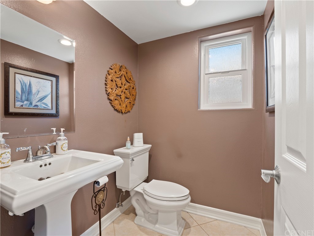 28043 Nantucket Street Castaic, CA 91384 - Photo 20 of 61 a bathroom with a toilet a sink and mirror