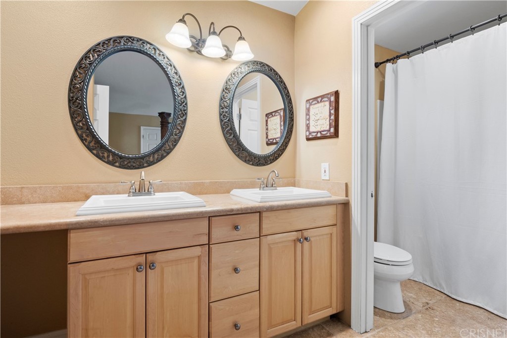 28043 Nantucket Street Castaic, CA 91384 - Photo 27 of 61 a bathroom with a toilet a sink and a mirror