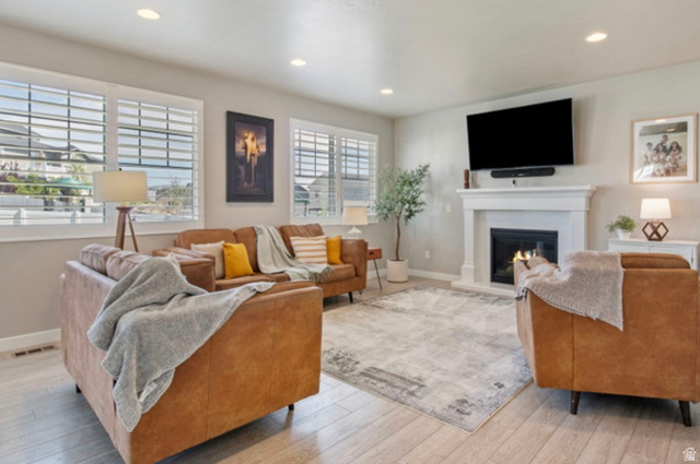 1295 East Granite Peak Road Eagle Mountain, UT 84005 - Photo 8 of 35 Living area featuring a white fireplace with a dark insert, a mounted television, and recessed ceiling lighting