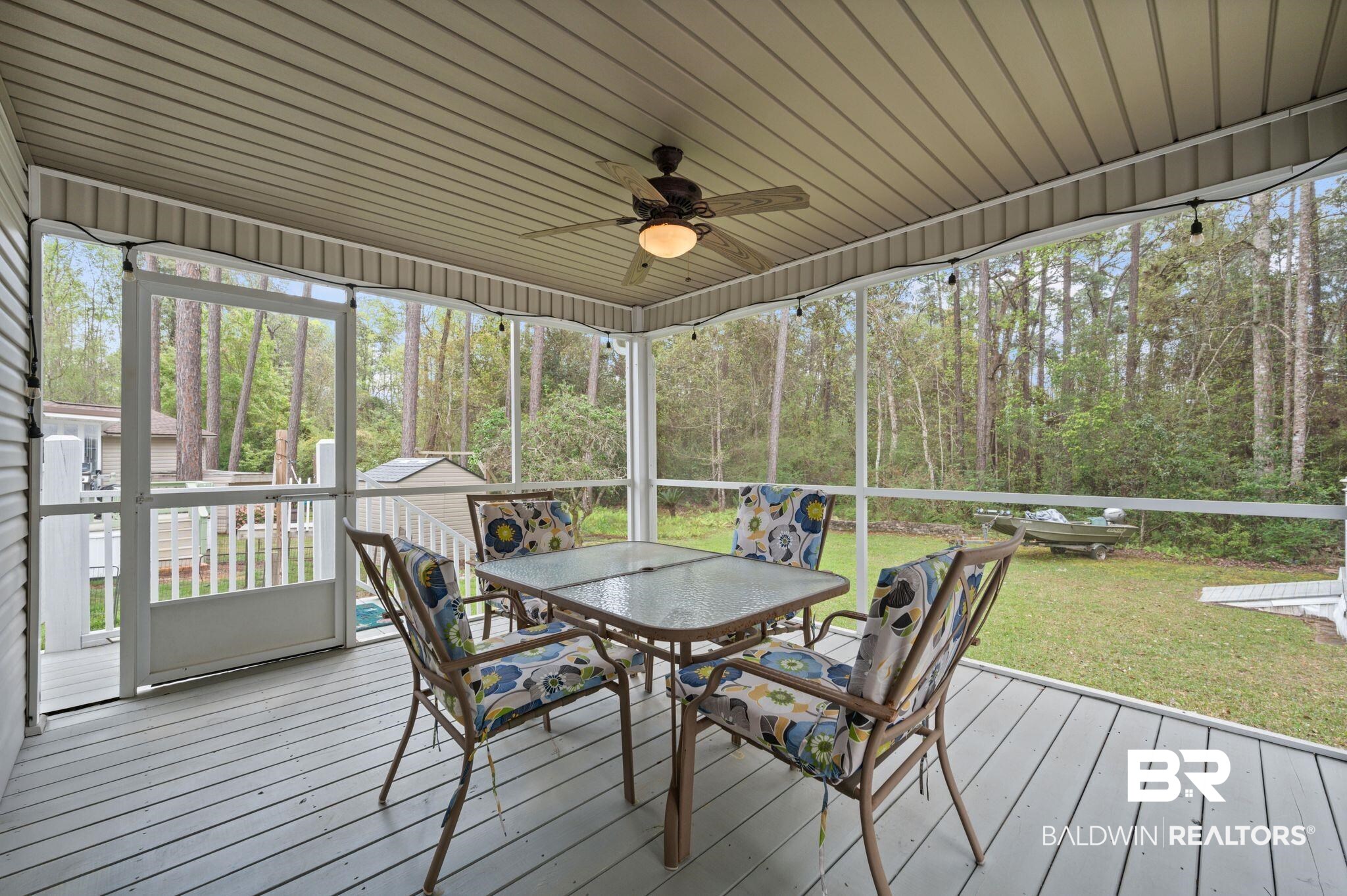 24711 County Road 20, Unit A11 Elberta, AL 36530 - Photo 20 of 35 Sunroom with ceiling fan, outdoor dining space, a deck, and view of scattered trees
