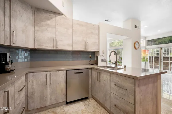 a kitchen with white cabinets and sink