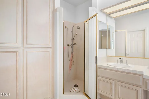 a bathroom with a shower sink and mirror