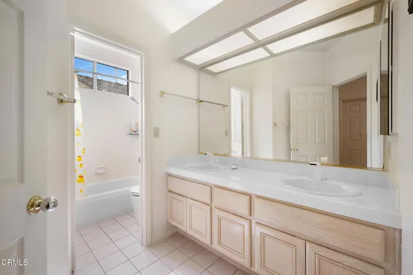 a bathroom with a granite countertop sink a mirror a shower and a bathtub
