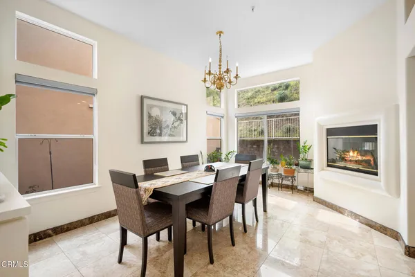 a dining room with furniture a chandelier and window