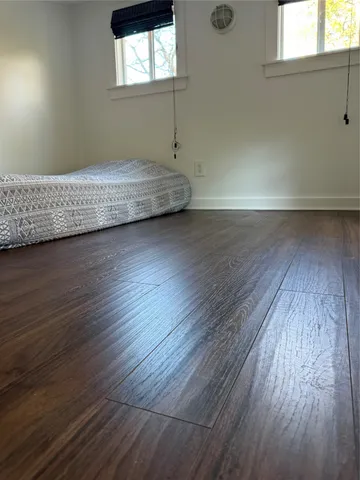 a view of a room with wooden floor and window