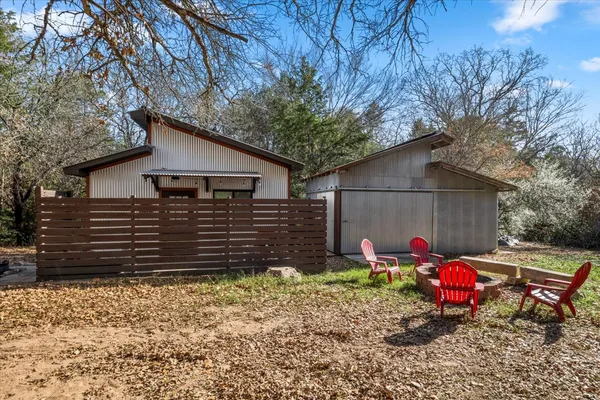 a view of a house with a backyard and chairs