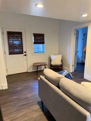 a bedroom with a bed a dresser and wooden floor