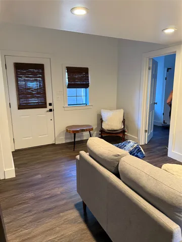 a living room with furniture and a wooden floor