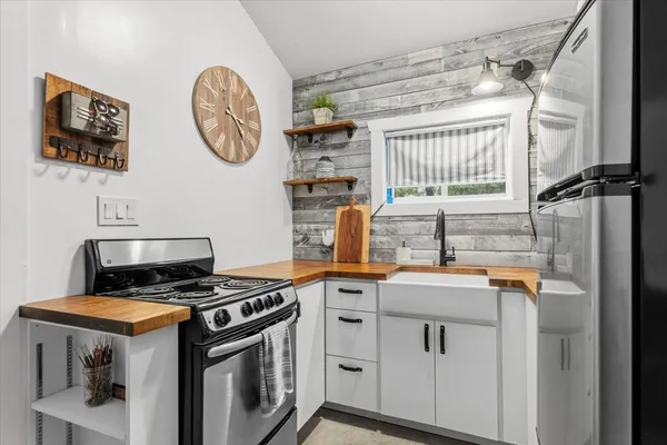 a kitchen with stainless steel appliances granite countertop a stove a sink and a window