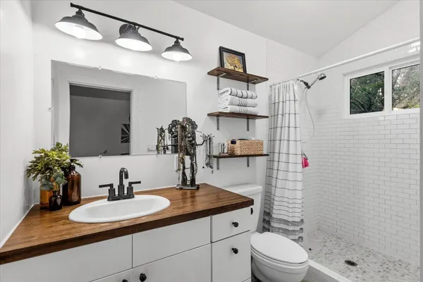 a bathroom with a granite countertop sink a toilet and shower