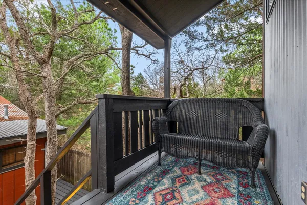 a balcony with wooden floor and outdoor seating