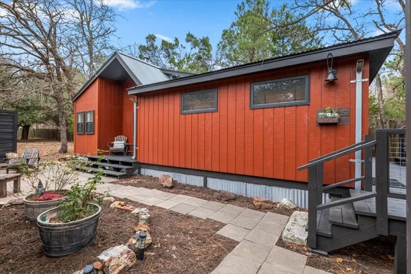 a backyard of a house with wooden fence and plants