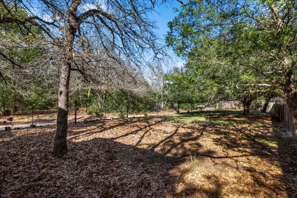 a view of a yard with lots of green space and trees
