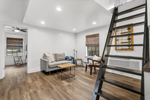 a living room with furniture and a wooden floor