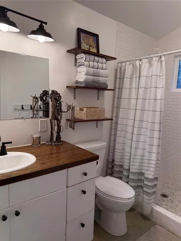 a bathroom with a granite countertop toilet sink and mirror