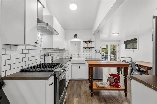 a kitchen with stainless steel appliances a stove a sink dishwasher and cabinets with wooden floor