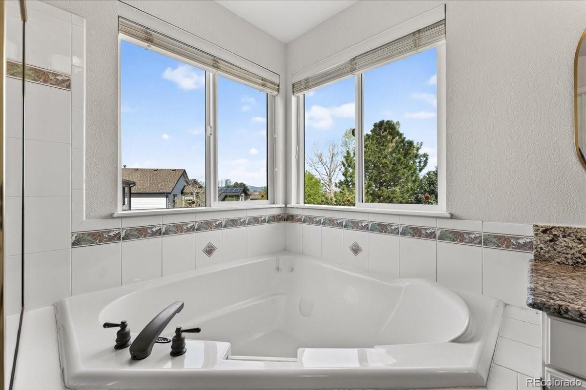 9477 Burgundy Circle Highlands Ranch, CO 80126 - Photo 29 of 50 a white bath tub sitting in a bathroom next to a window