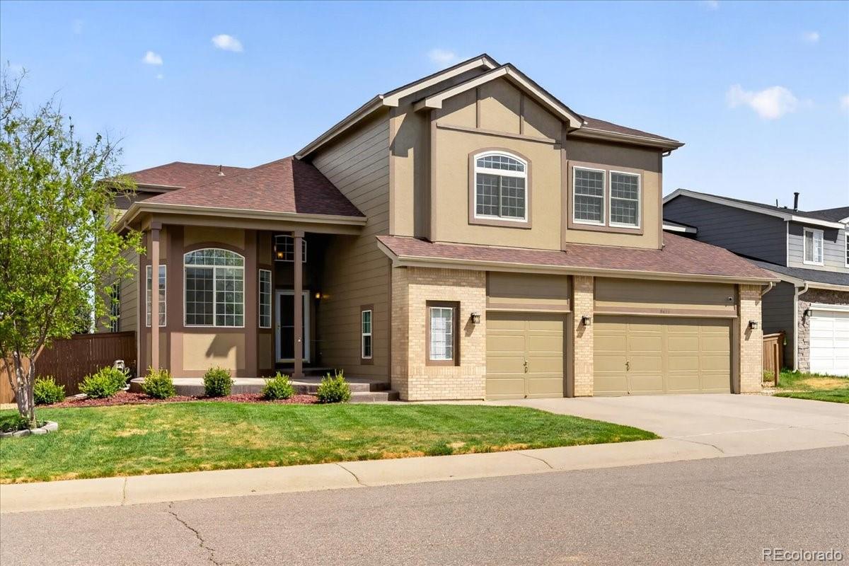 9477 Burgundy Circle Highlands Ranch, CO 80126 - Photo 3 of 50 a front view of a house with a yard and garage