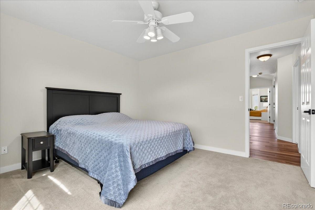 9477 Burgundy Circle Highlands Ranch, CO 80126 - Photo 34 of 50 a bedroom with a bed and a chandelier