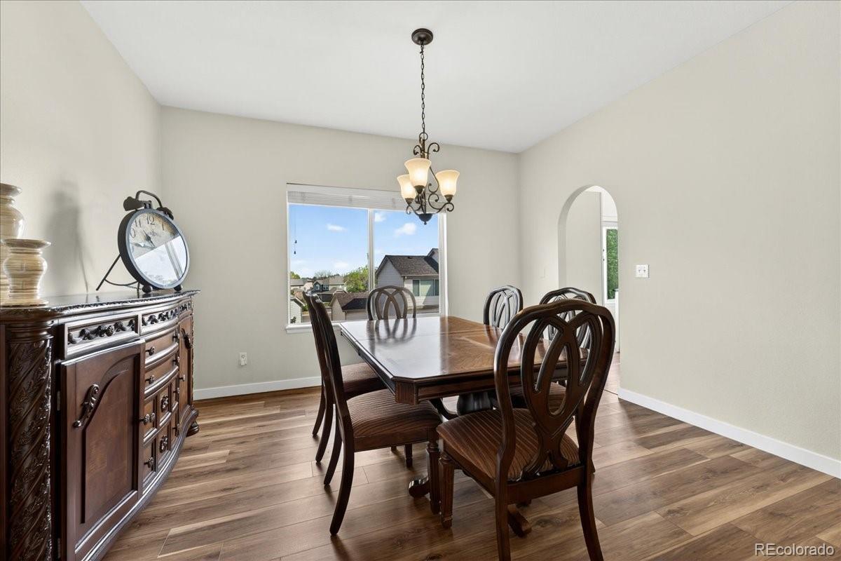 9477 Burgundy Circle Highlands Ranch, CO 80126 - Photo 10 of 50 a dining room with furniture a chandelier and wooden floor