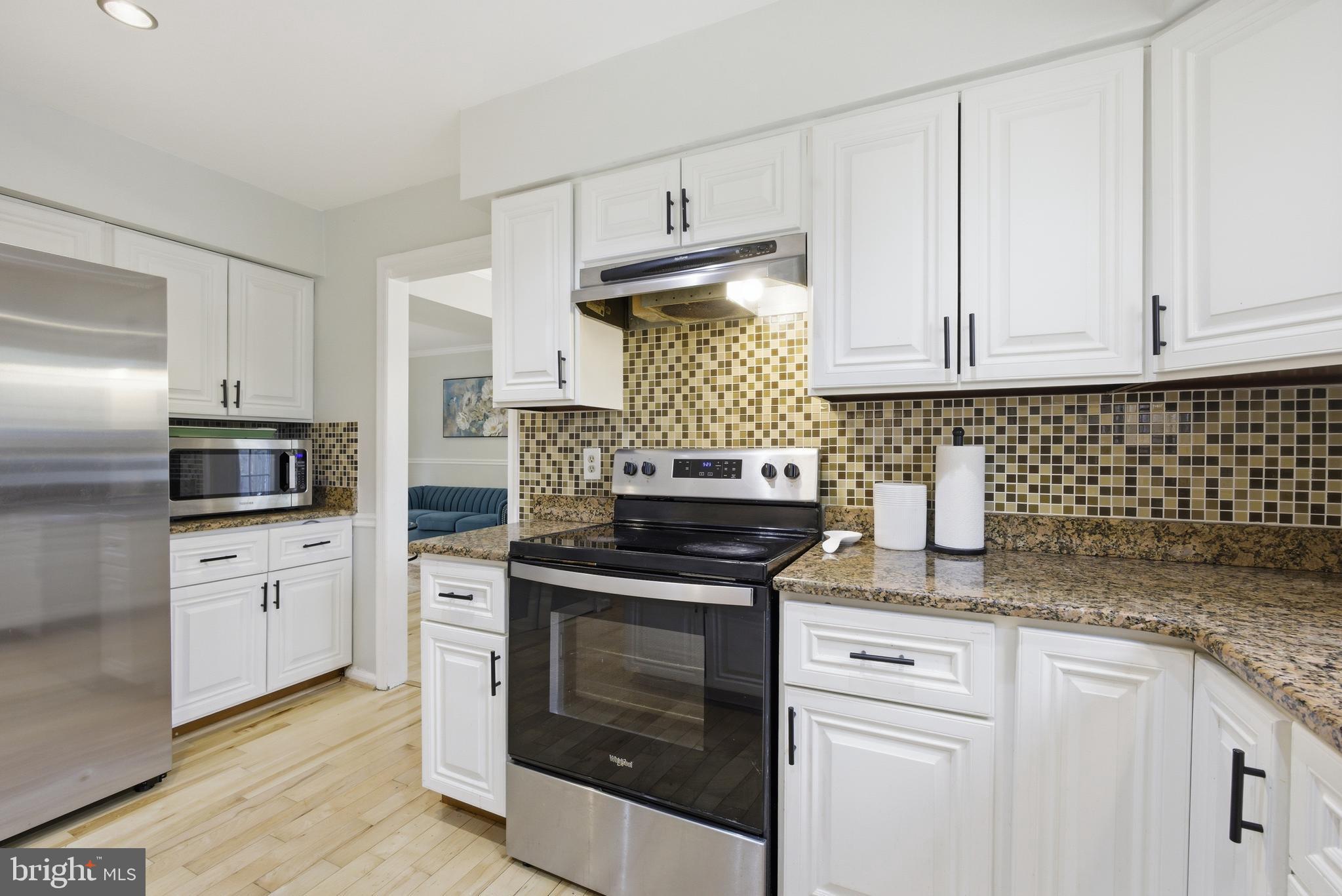8664 Pohick Forest Court Springfield, VA 22153 - Photo 11 of 41 a kitchen with granite countertop white cabinets and stainless steel appliances