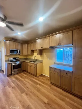 a kitchen with granite countertop a sink cabinets and stainless steel appliances