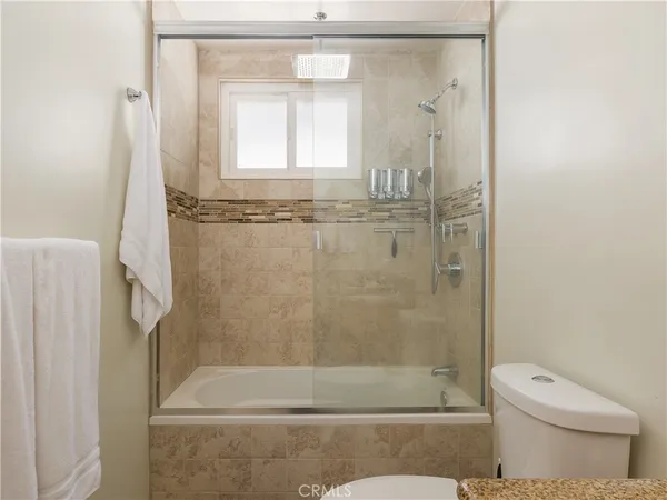 a bathroom with a shower a toilet and a window
