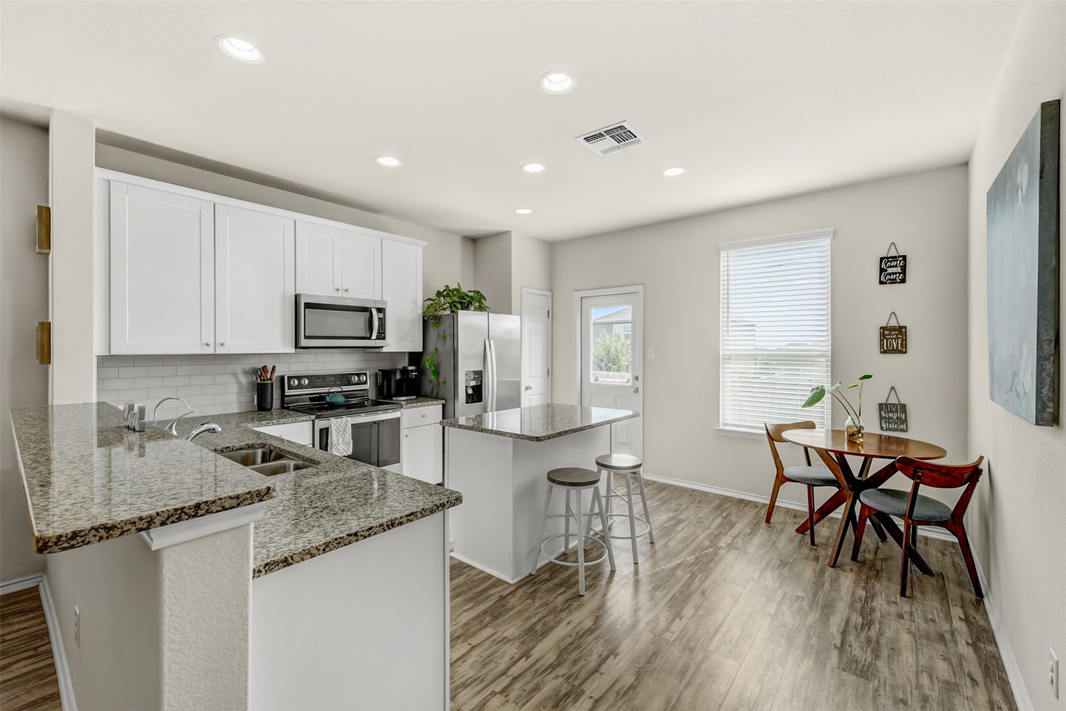 213 Ibis Falls Loop Jarrell, TX 76537 - Photo 10 of 37 A contemporary kitchen and dining space featuring an island and bright recessed lighting.