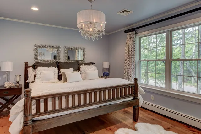 a bed sitting in a bedroom next to a window