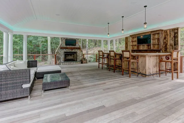 a living room with furniture large flat screen tv and a fireplace