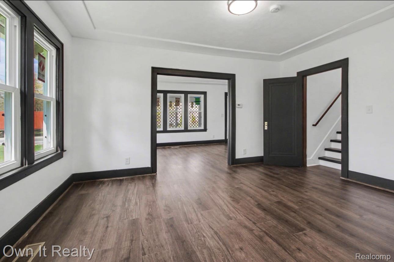 6023 Wayne Road Romulus, MI 48174 - Photo 8 of 25 Spare room with dark wood finished floors and stairs