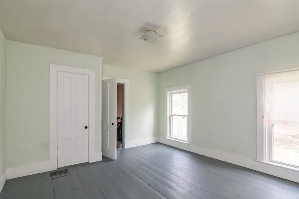 a view of a bedroom with wooden floor