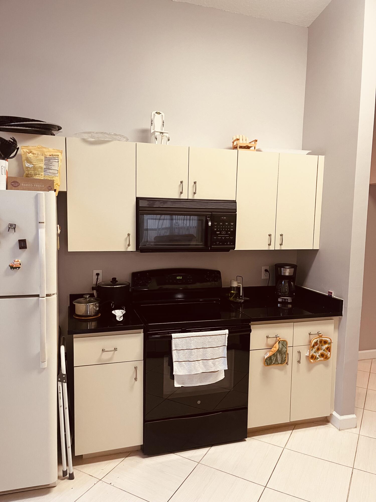 3502 Ridge Tree Court, Unit E Greenacres, FL 33463 - Photo 4 of 17 a kitchen with a sink and a refrigerator