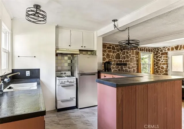 a kitchen with a refrigerator a stove and a wooden floor