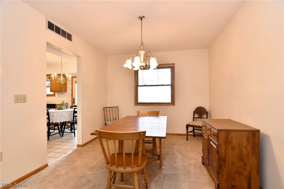 7655 Bellflower Road Mentor, OH 44060 - Photo 5 of 28 Dining space featuring light carpet and a notable chandelier