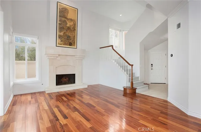 a view of empty room with wooden floor and a fireplace