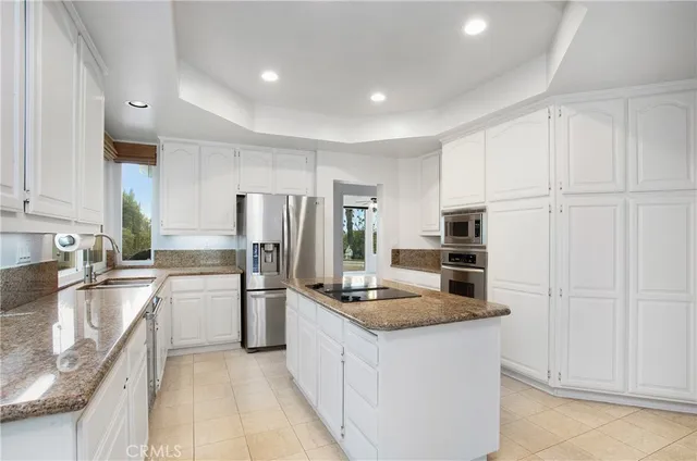a kitchen with stainless steel appliances granite countertop a refrigerator and a sink