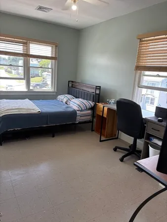 a bedroom with a bed chair and a window