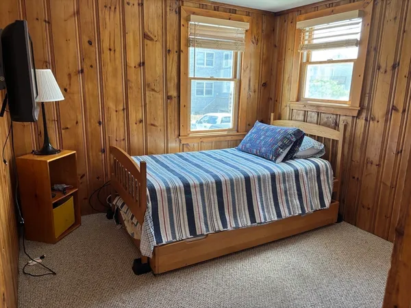 a bed sitting in a bedroom next to a window