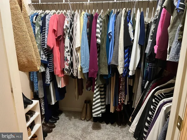 a bedroom with a bed a computer on a desk and chair