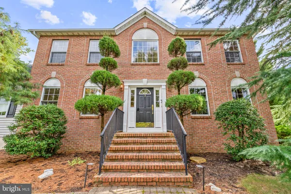 a front view of a house with a yard and potted plants